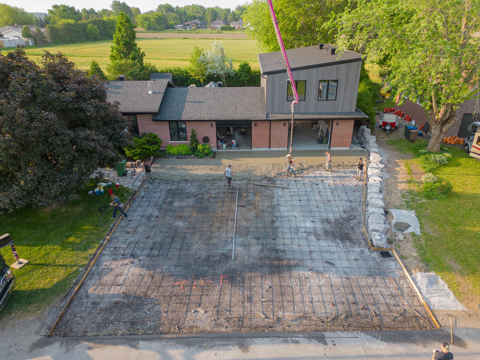 Une vue aérienne d’une allée en béton en construction devant une maison.