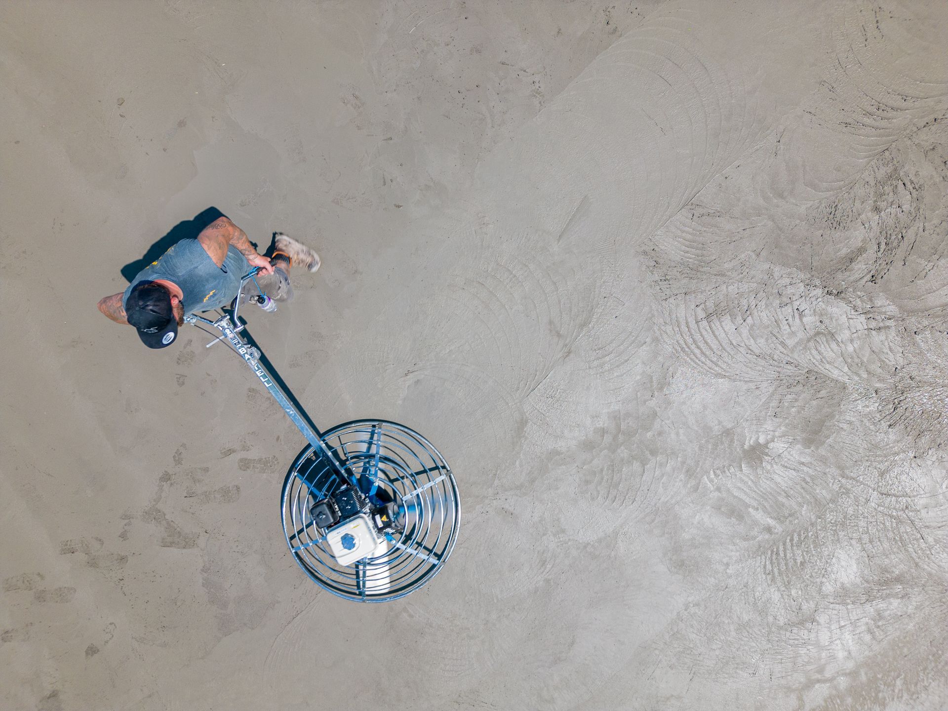 Vue aérienne d'un homme utilisant une machine sur une surface en béton.