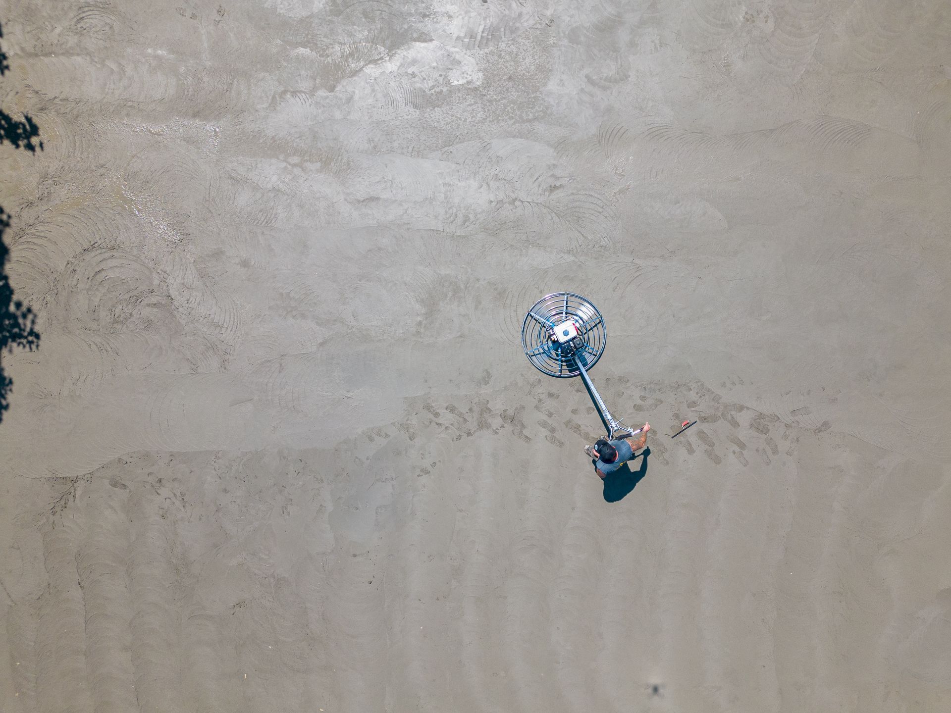 Vue aérienne d'une personne utilisant une machine sur une surface en béton.