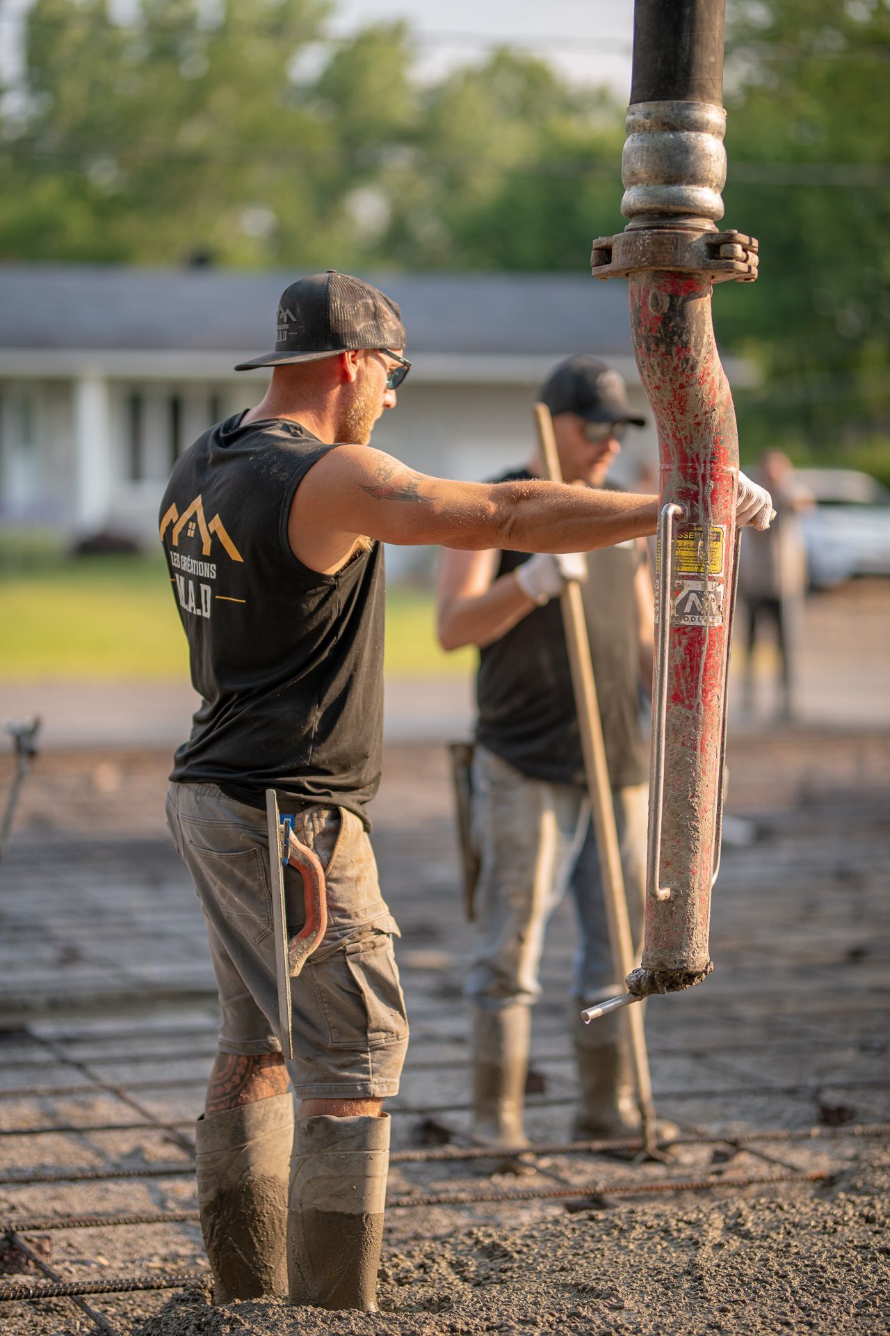Un homme pompe du béton dans une dalle de béton.