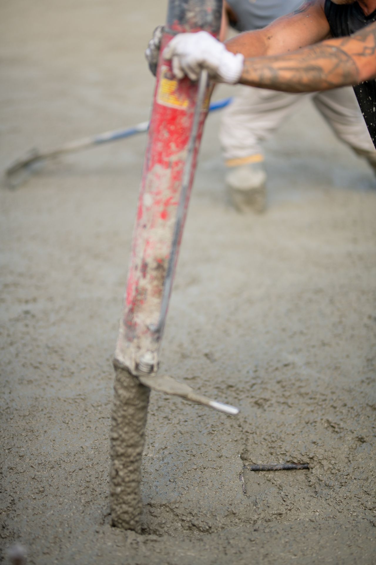 Un homme pompe du béton dans le sol avec une pompe à béton.