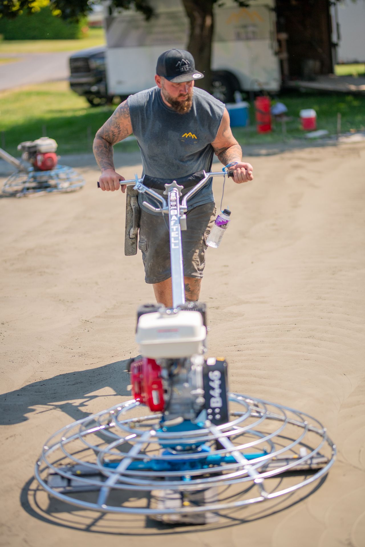 Un homme conduit une machine sur un chemin de terre.