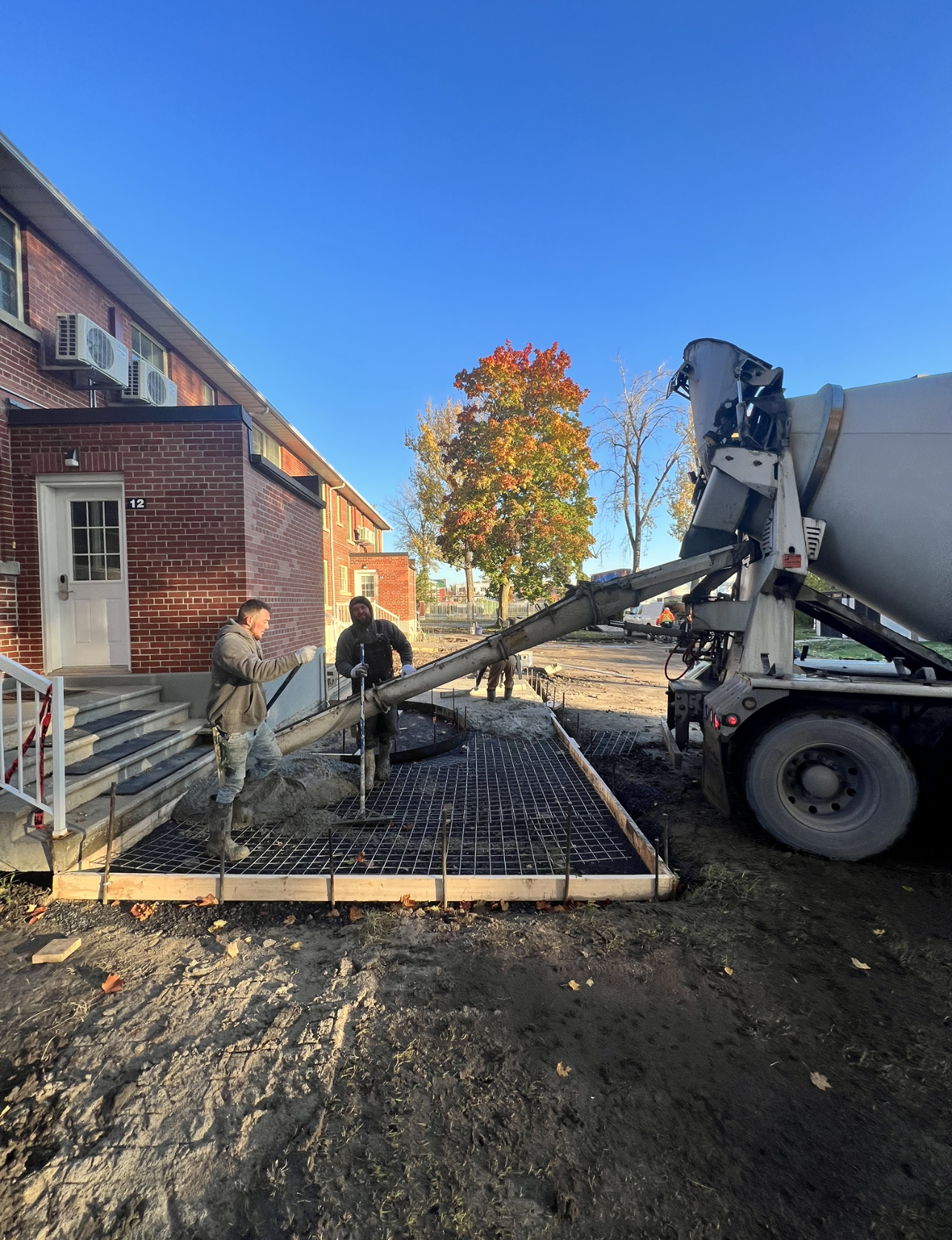 Un camion malaxeur à béton coule du béton dans une dalle de béton.