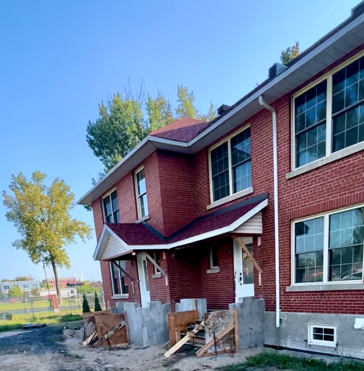 Une maison en brique avec un toit rouge et de nombreuses fenêtres