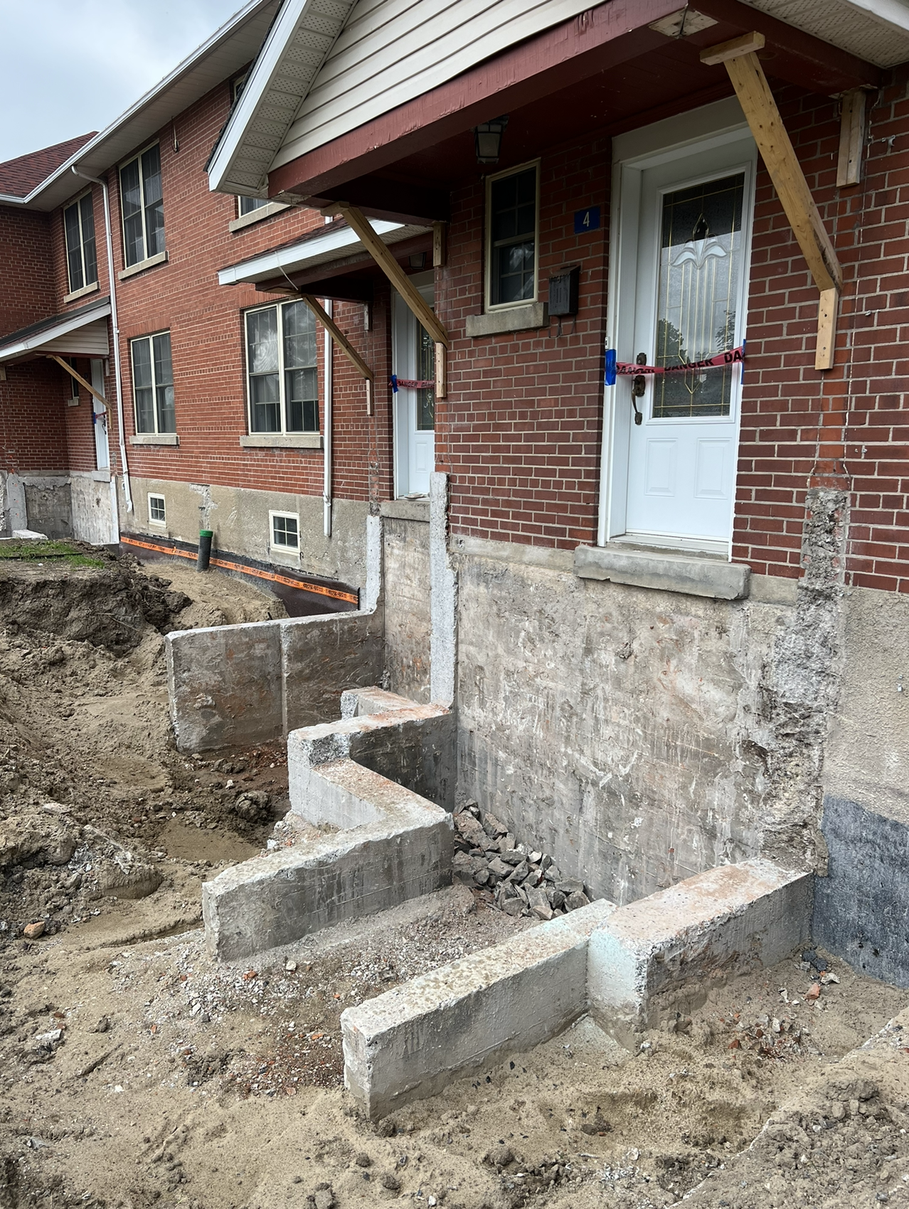 Une maison en brique avec des marches en béton menant à la porte d'entrée.