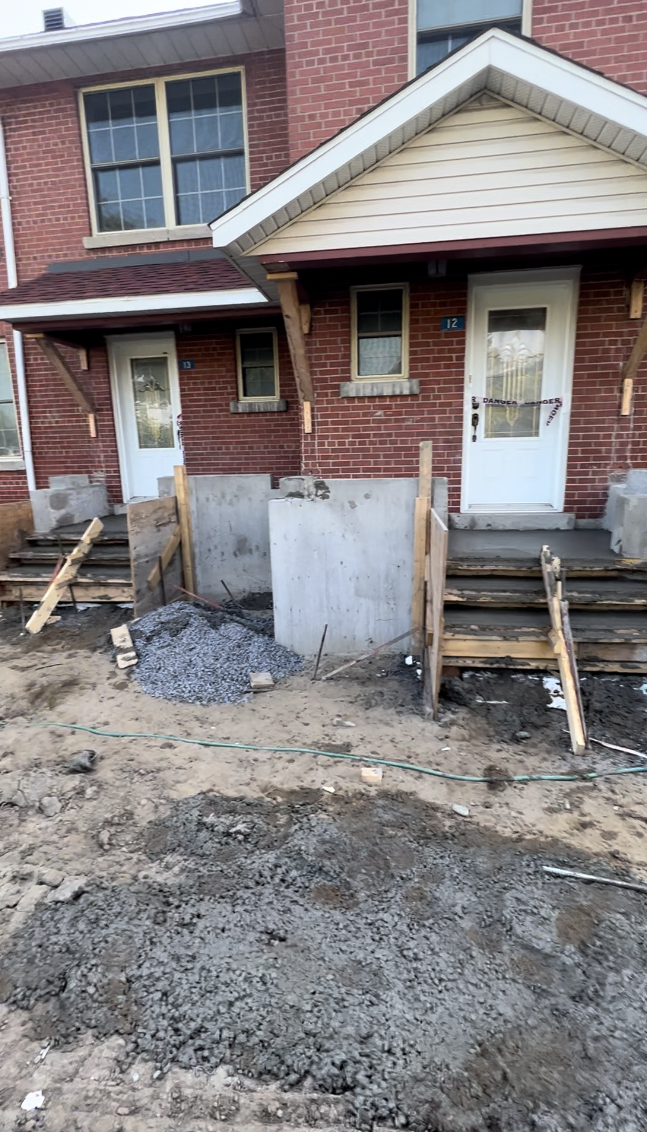 Une maison en brique avec un porche et des escaliers en construction.