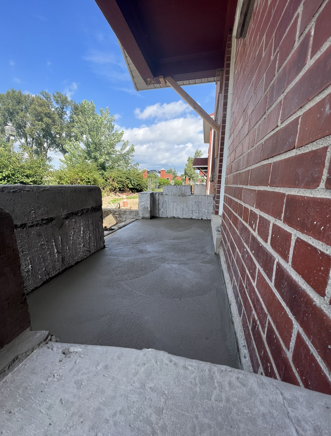 Un bâtiment en brique avec une passerelle en béton devant.
