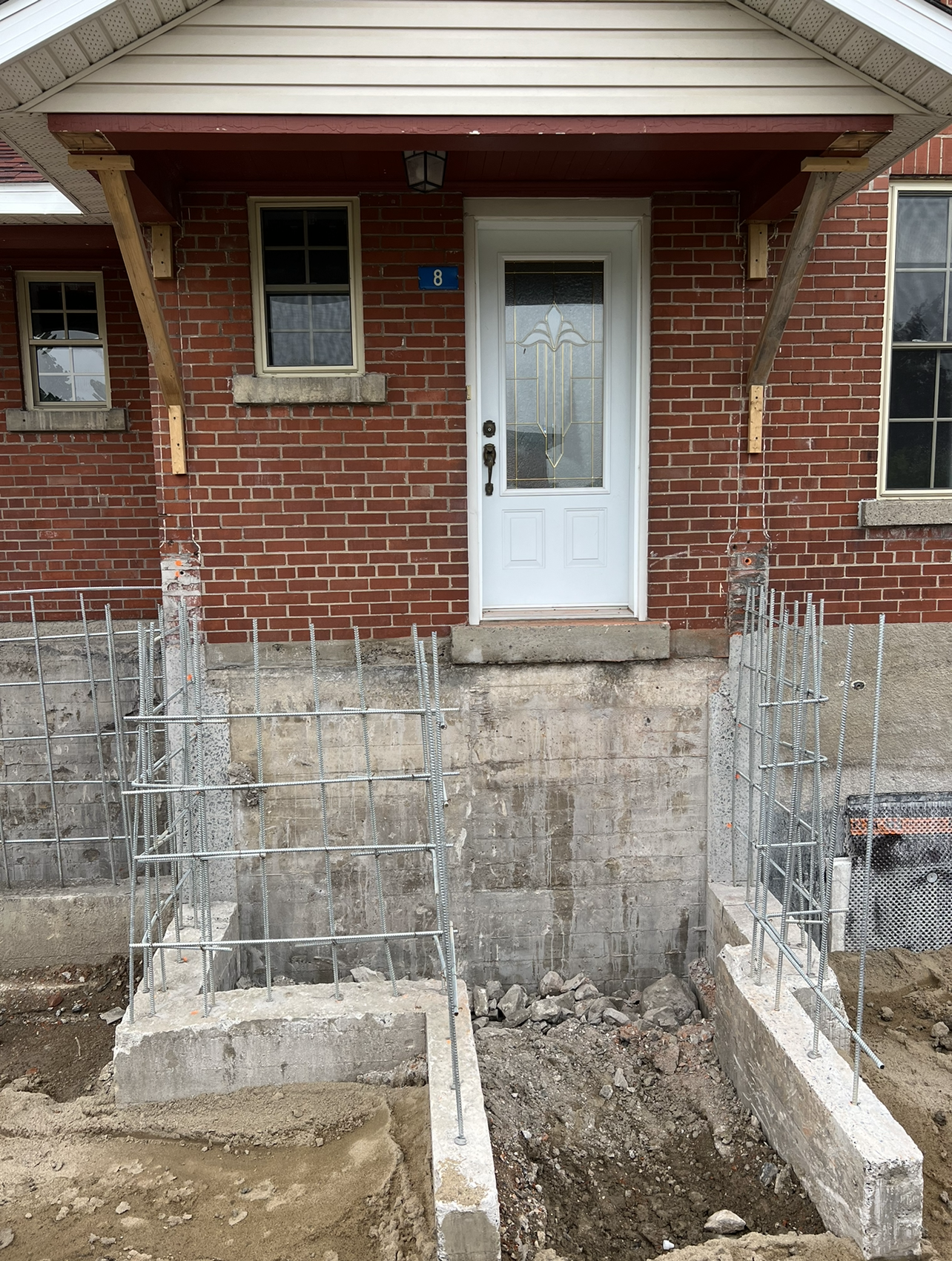 Une maison en brique avec une porte blanche est en cours de rénovation.