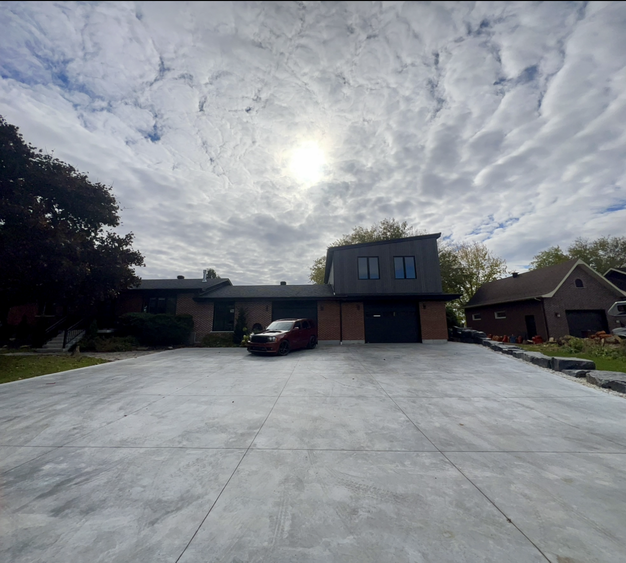 Une voiture est garée dans une allée devant une maison