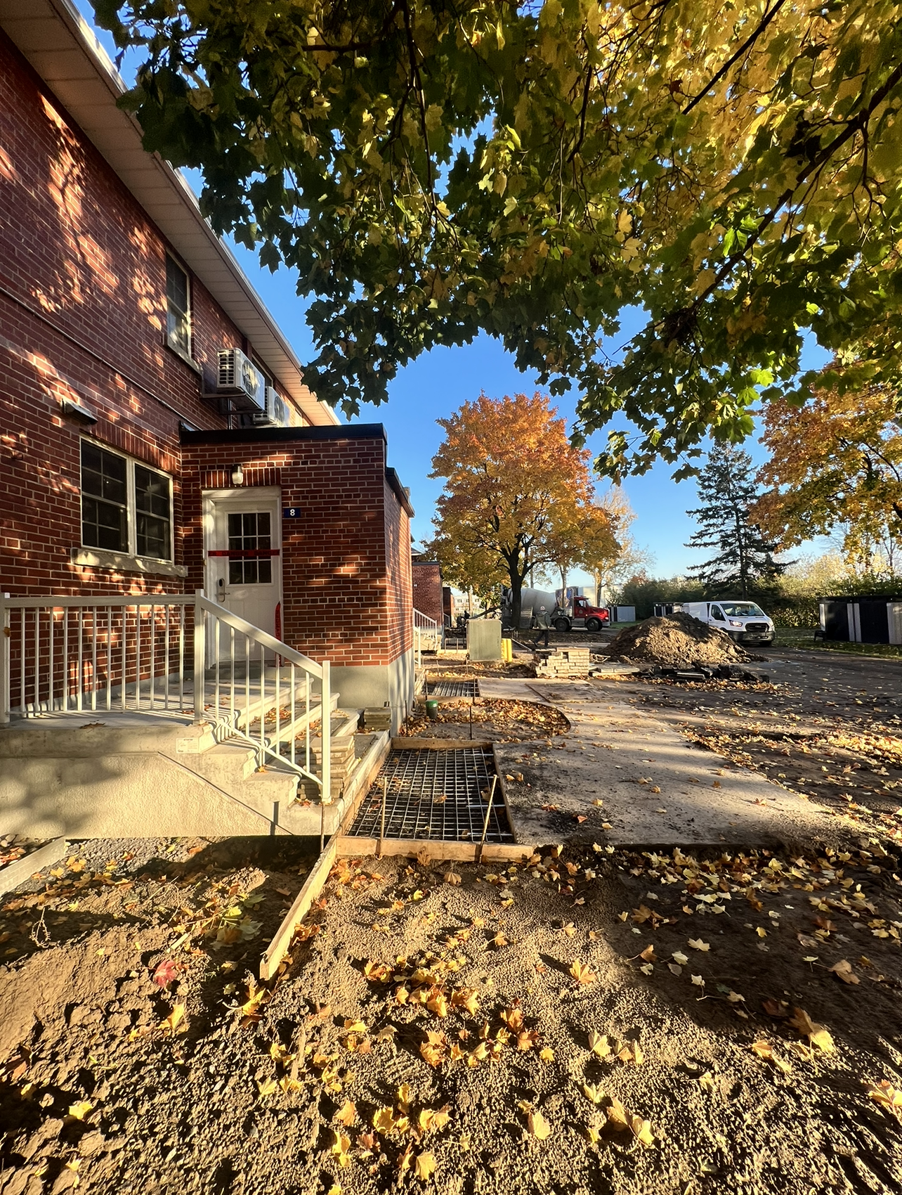 Un bâtiment en brique avec des escaliers et un arbre devant.