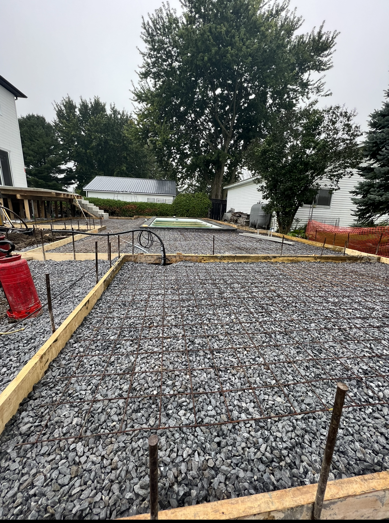 Une allée en gravier est en cours de construction devant une maison.