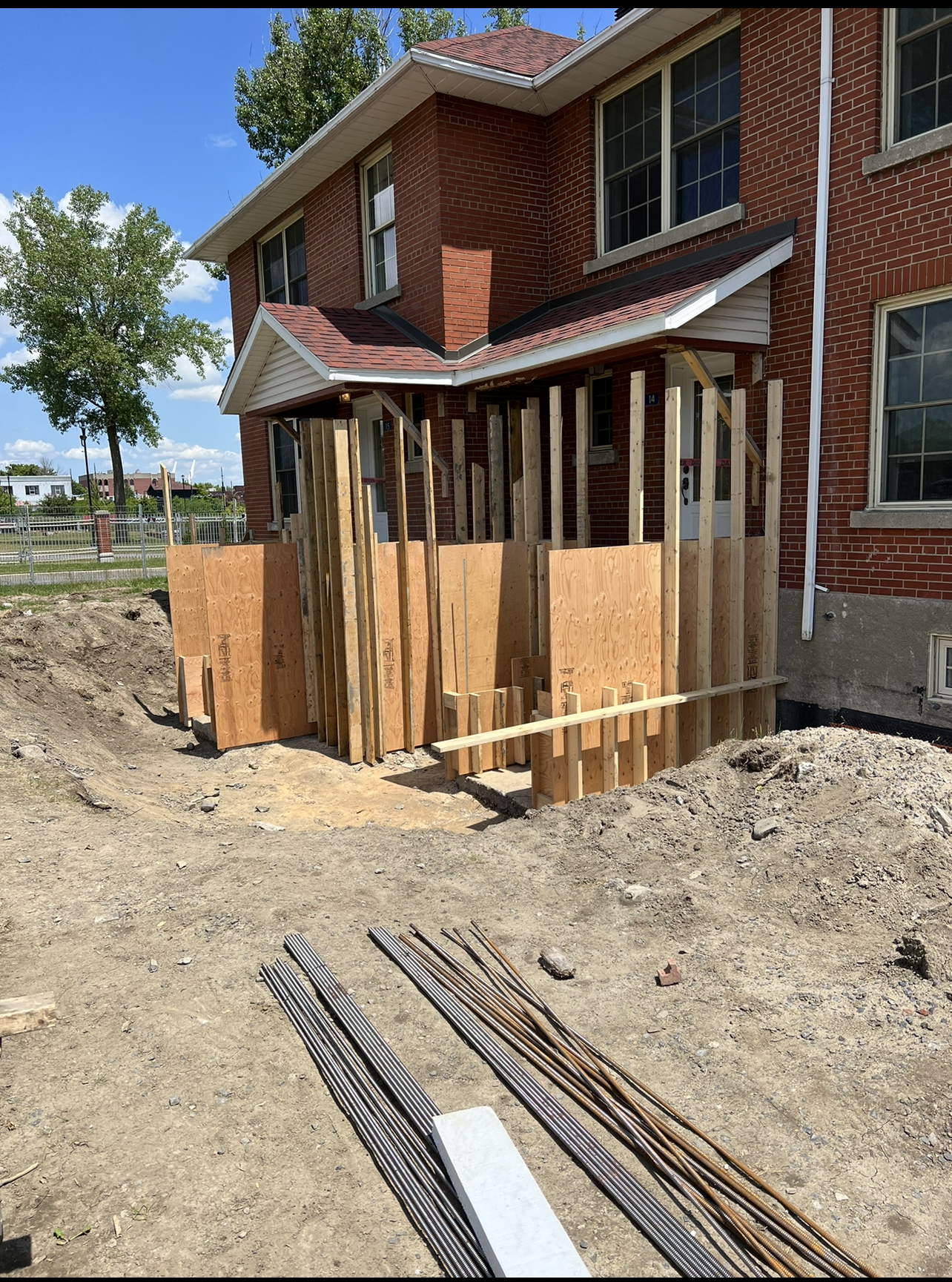 Une maison en brique est en cours de rénovation et un porche est en cours de construction.