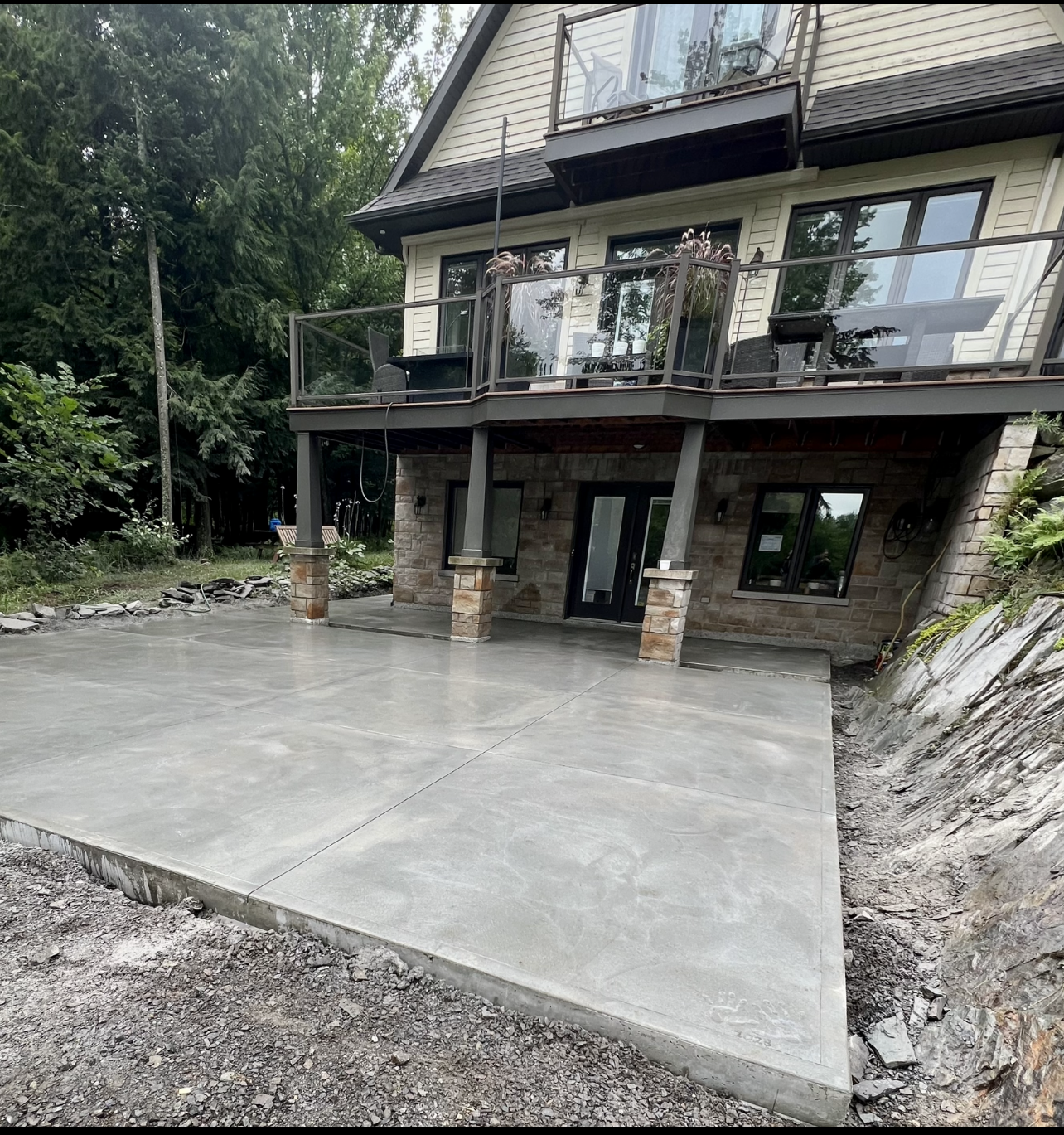 Une grande maison avec un patio en béton devant.