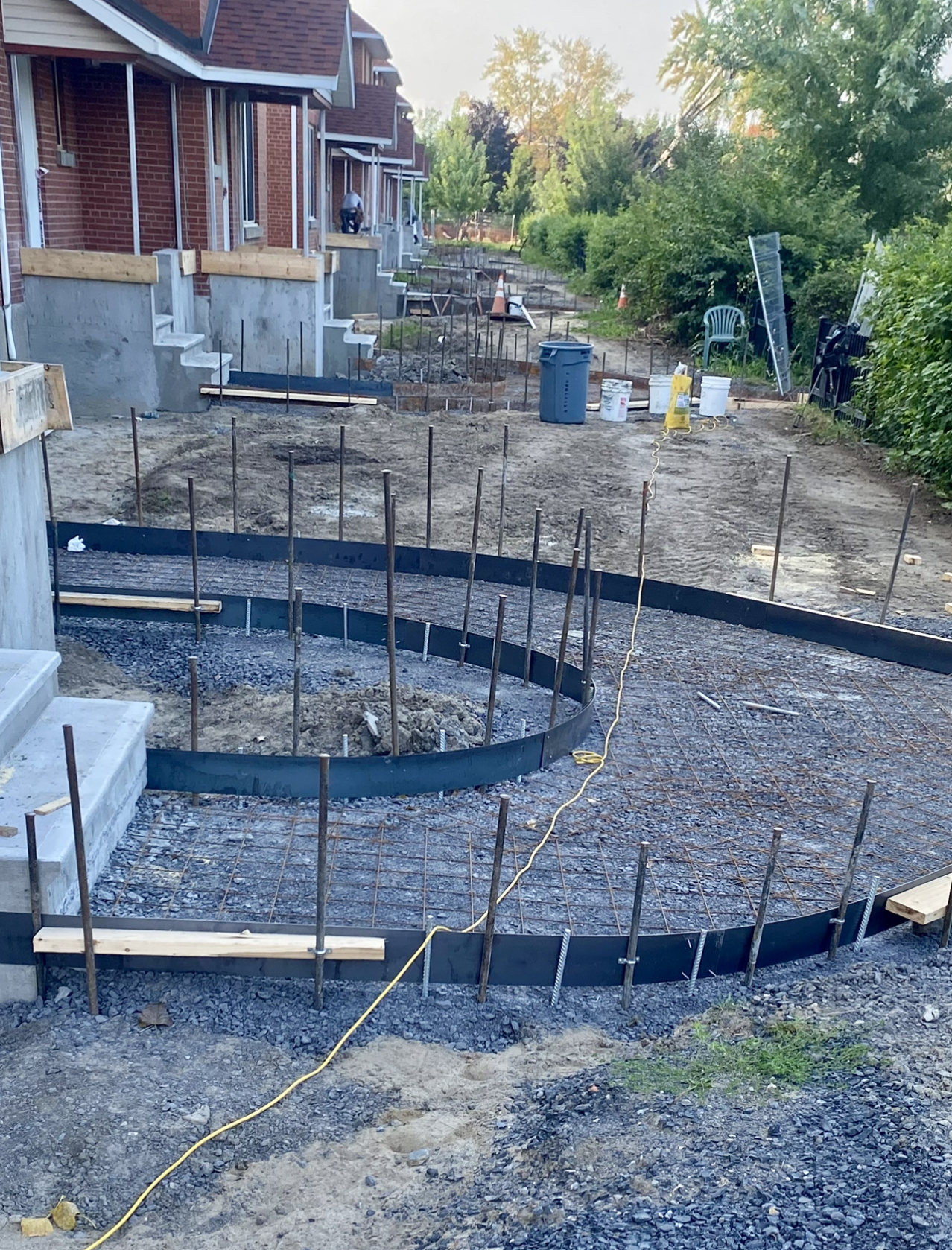 Une passerelle en béton est en cours de construction devant une rangée de maisons