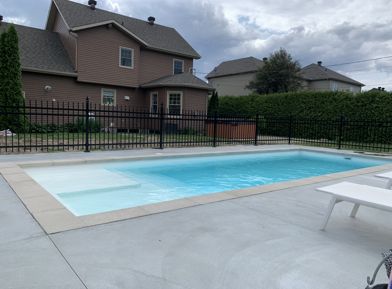 Il y a une grande piscine dans la cour d'une maison.