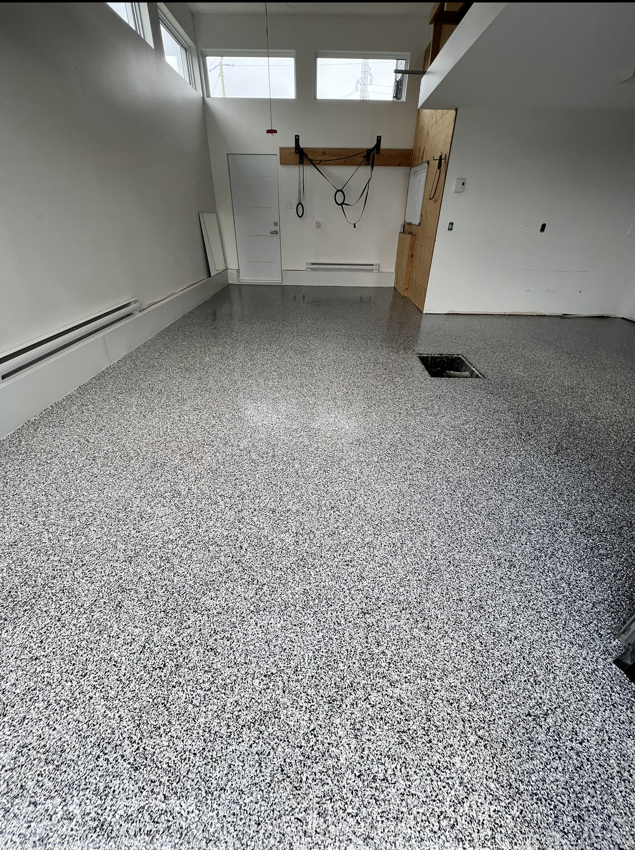 Un garage avec un sol gris et des murs blancs