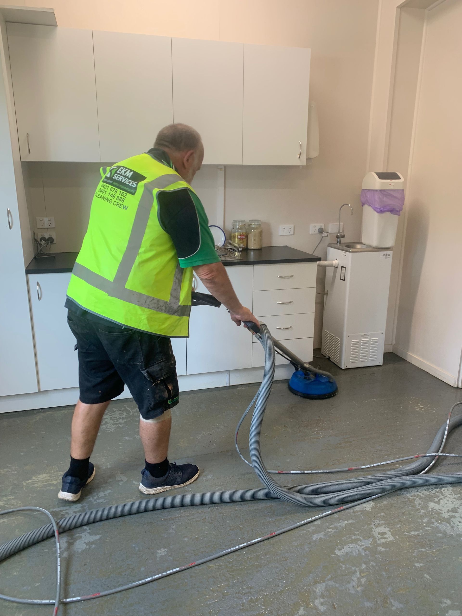 Yellow hard hat, blueprints, and construction tools on a work surface, suggesting a construction or renovation project.