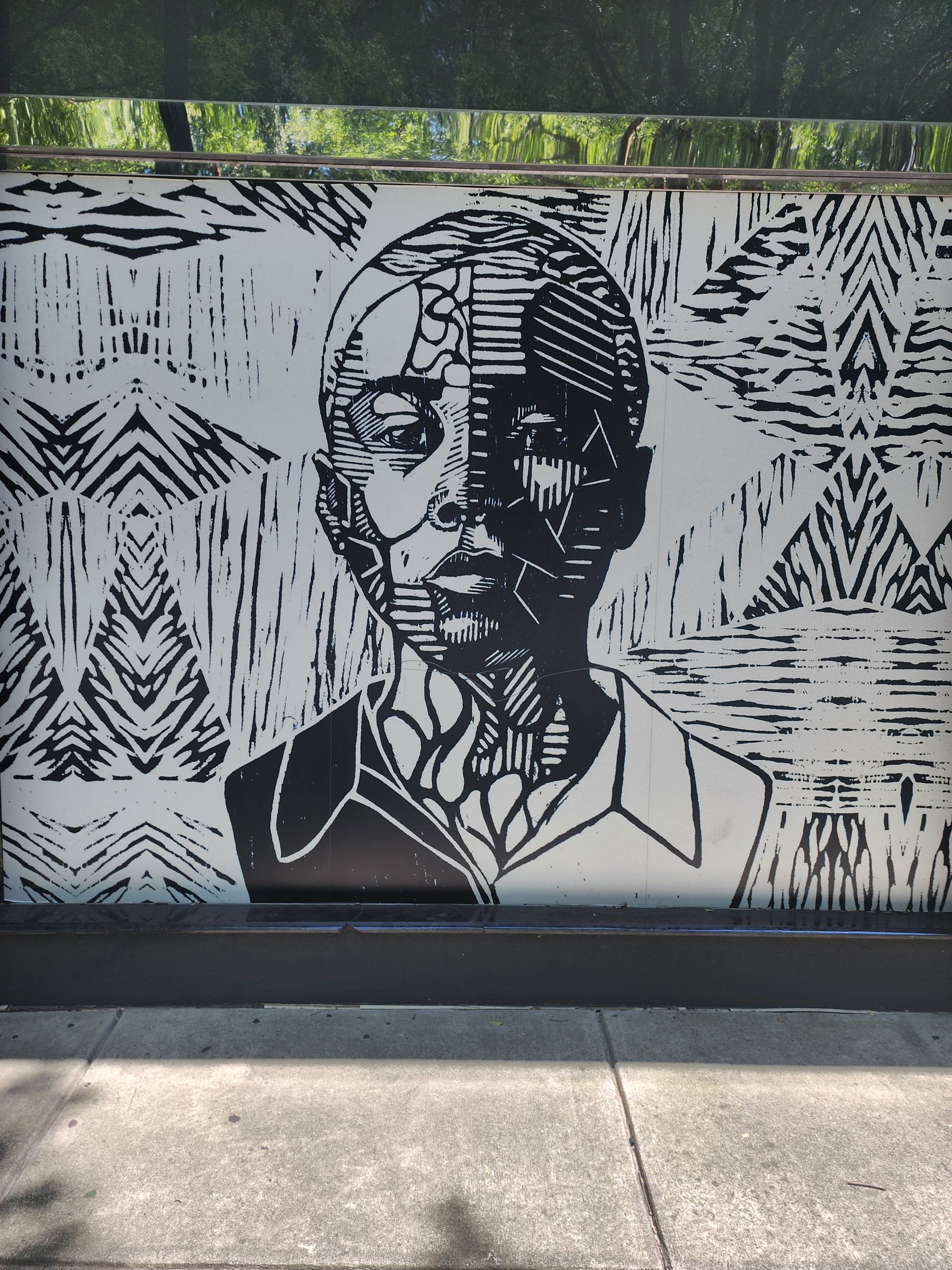 Black and white mosaic portrait of a person with symmetrical geometric design, outdoor setting.