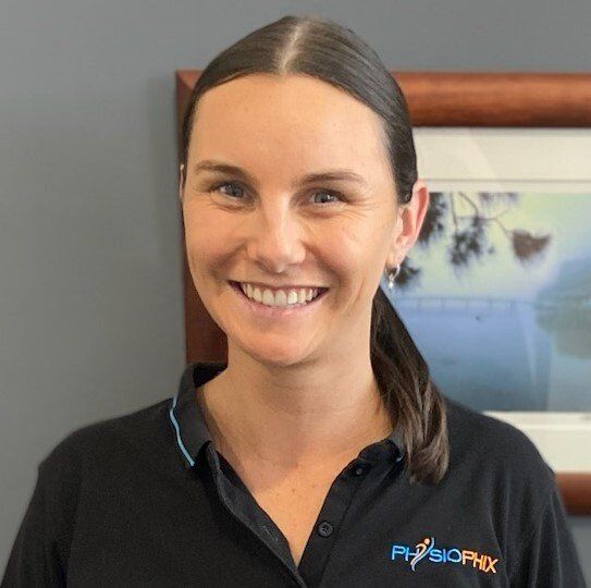 Woman with brown hair smiling in a black shirt with
