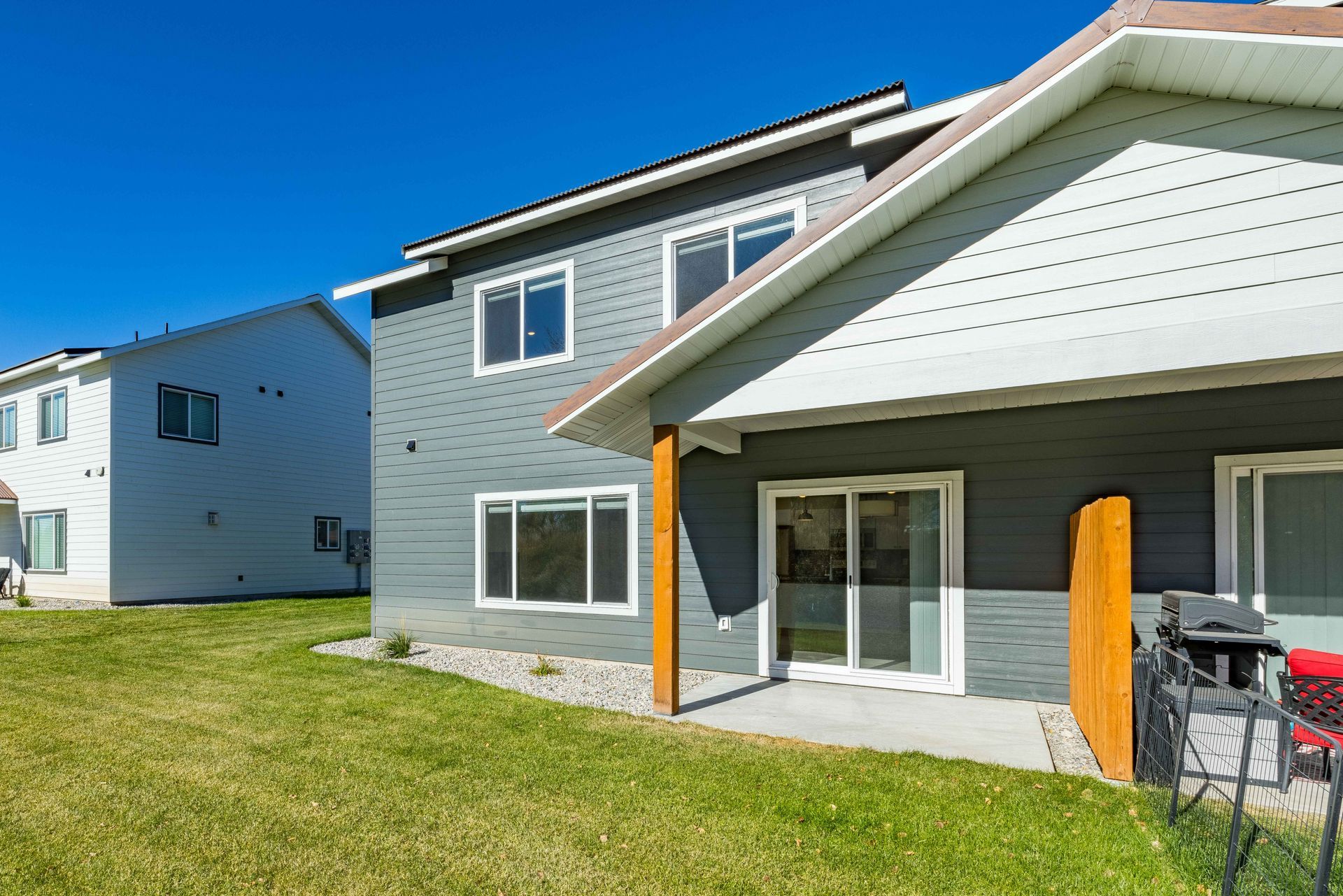 A house with a sliding glass door and a grill in front of it.