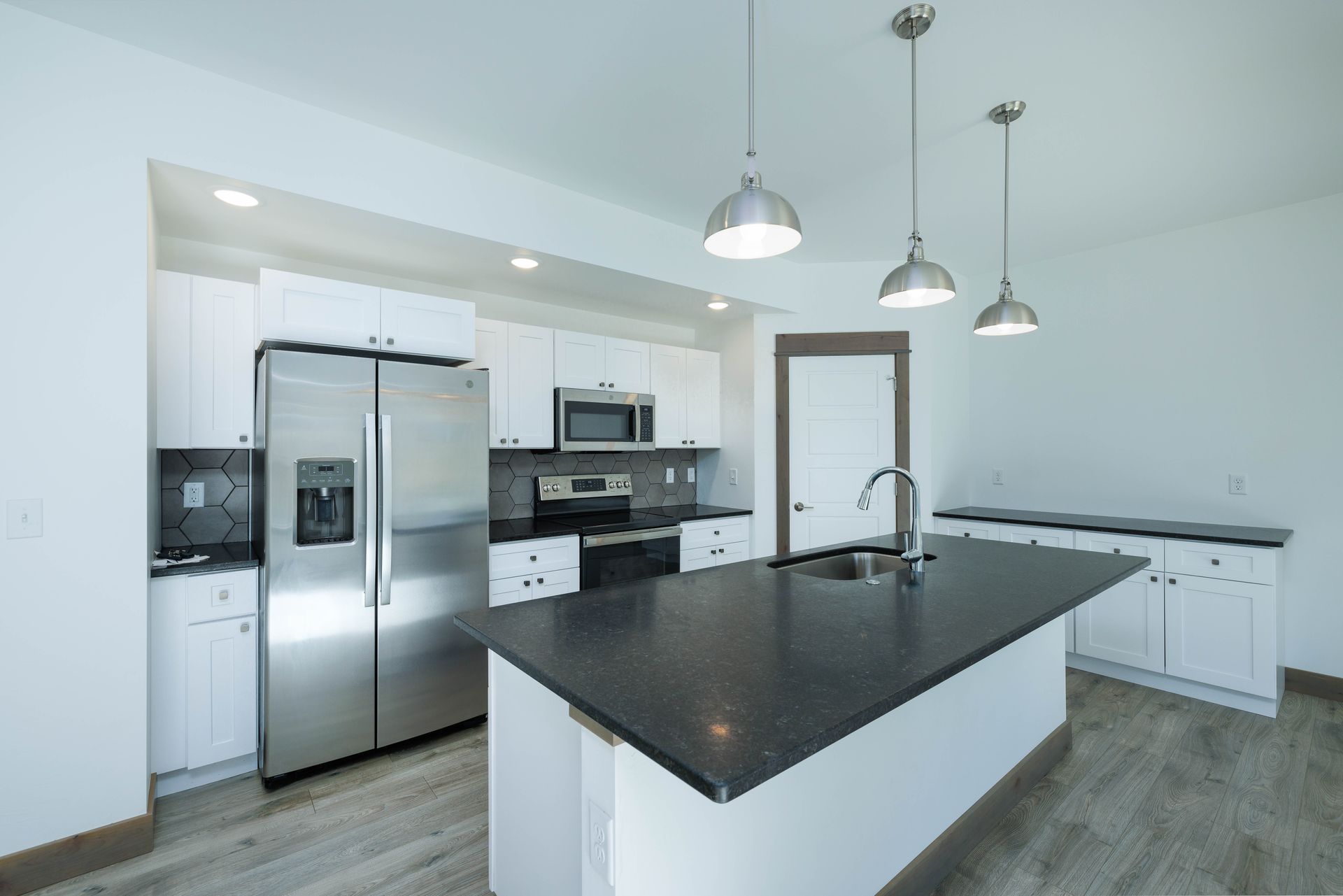 A kitchen with stainless steel appliances and a large island.