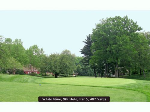 Golf course, White Nine, 9th Hole, a par 5, 482 yards. Green grass, trees, and a distant building.