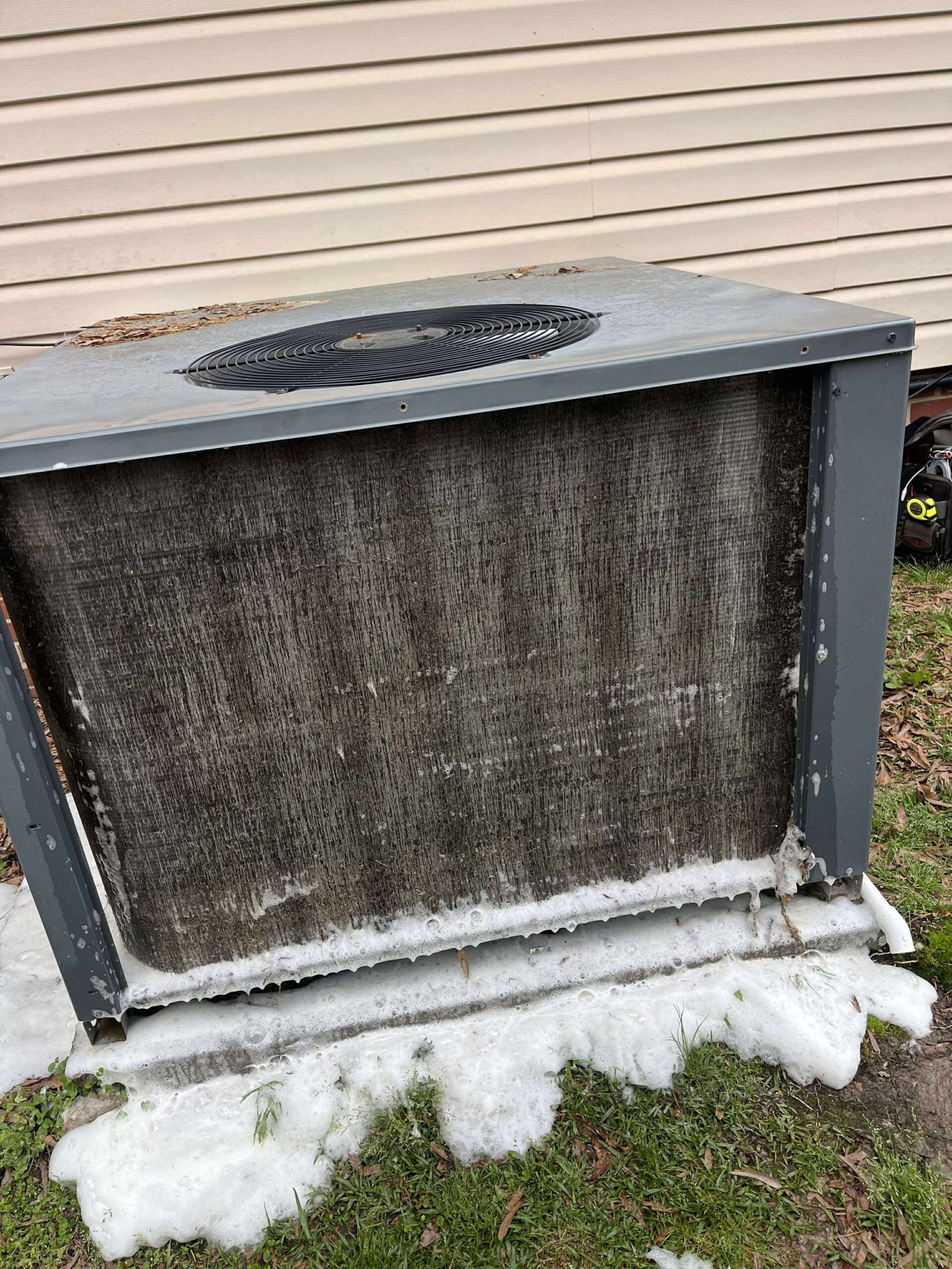 Outdoor air conditioning unit covered in dirt and ice.
