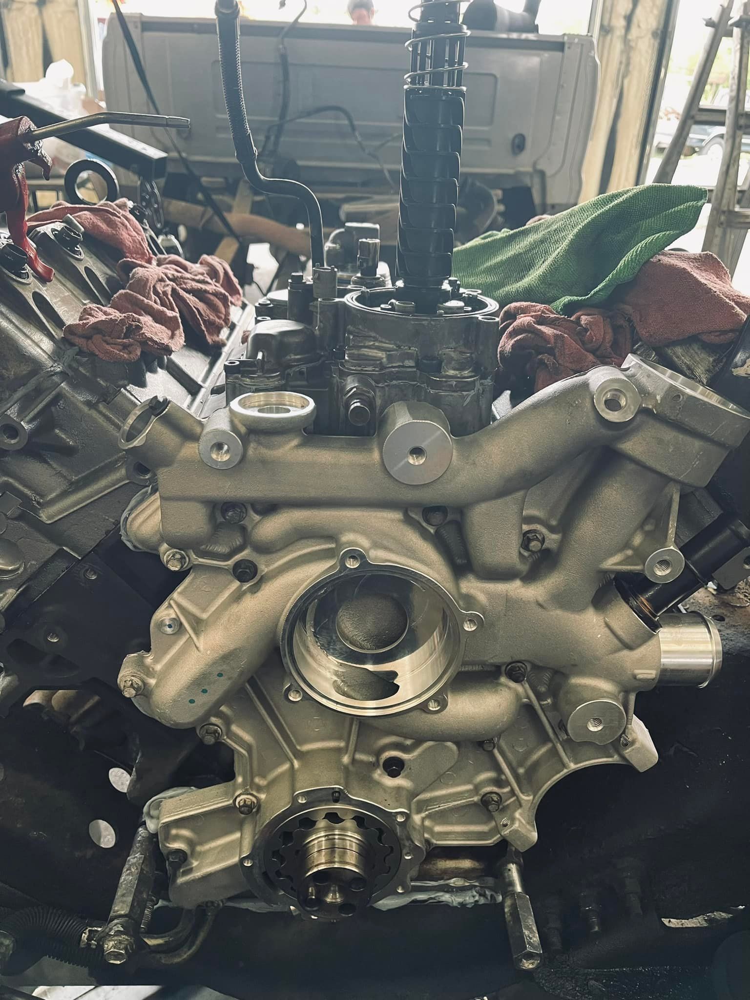 Engine block being worked on, with various components and tools visible.