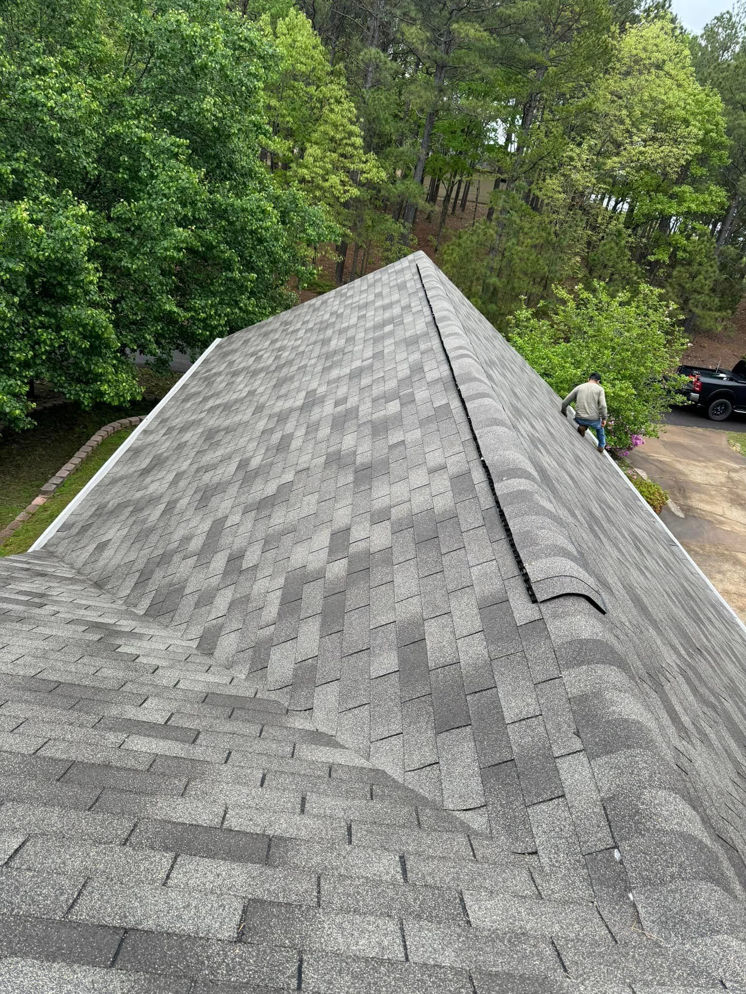 A man is standing on the roof of a house.