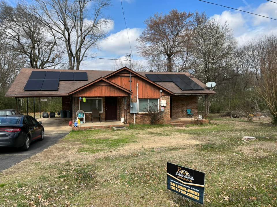 A house with solar panels on the roof and a car parked in front of it.