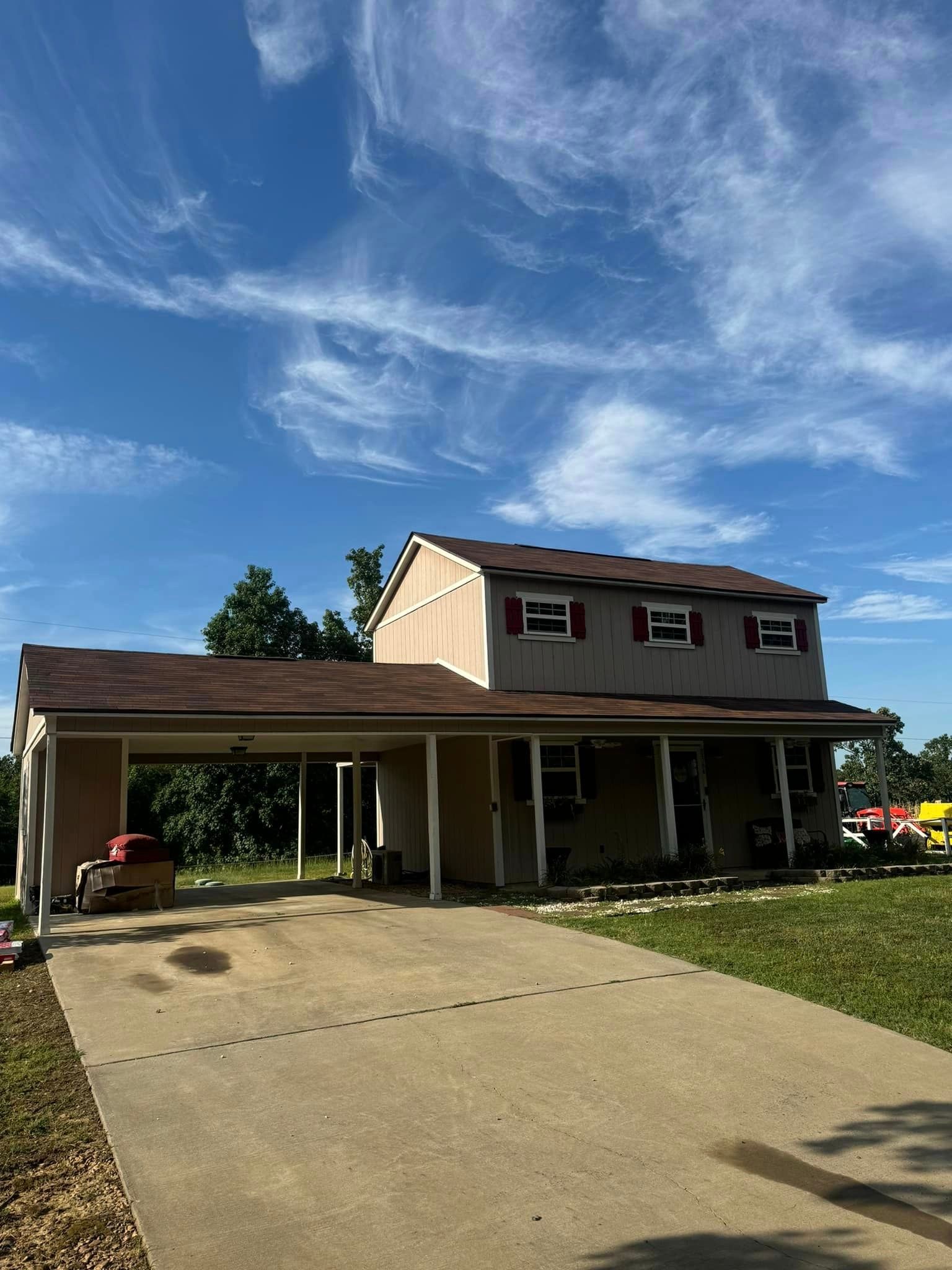 A house with a driveway and a porch on a sunny day.