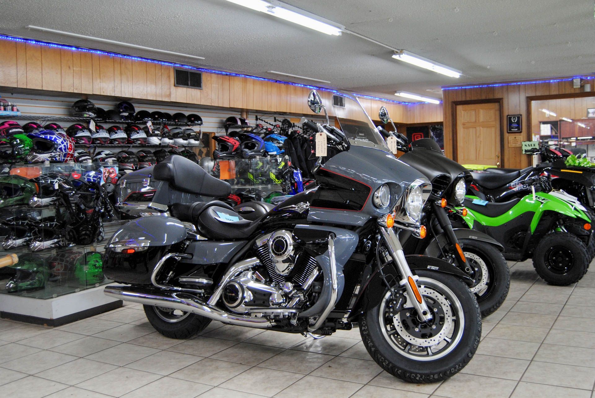 A row of motorcycles are parked in a showroom.