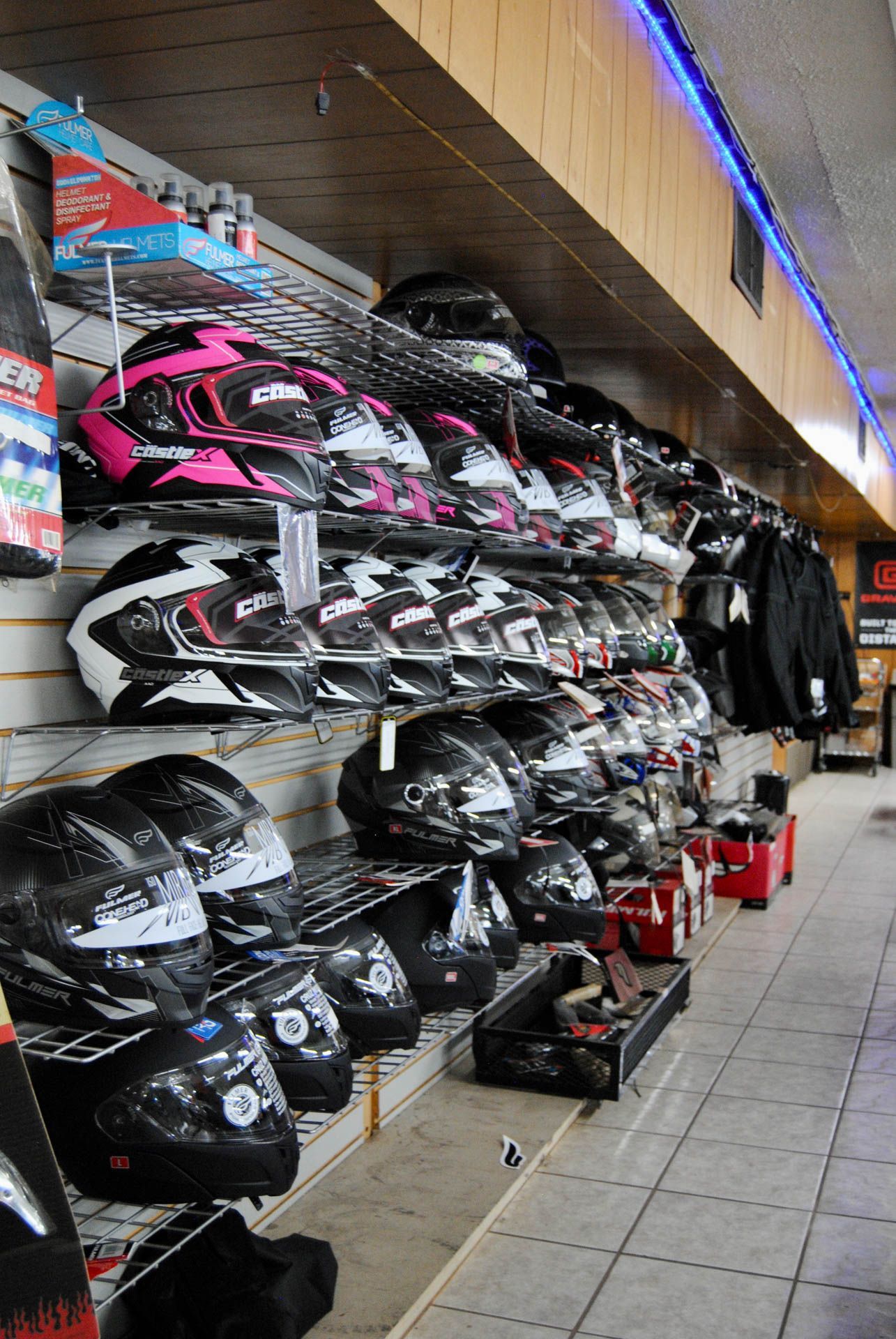 A store filled with lots of motorcycle helmets on shelves.