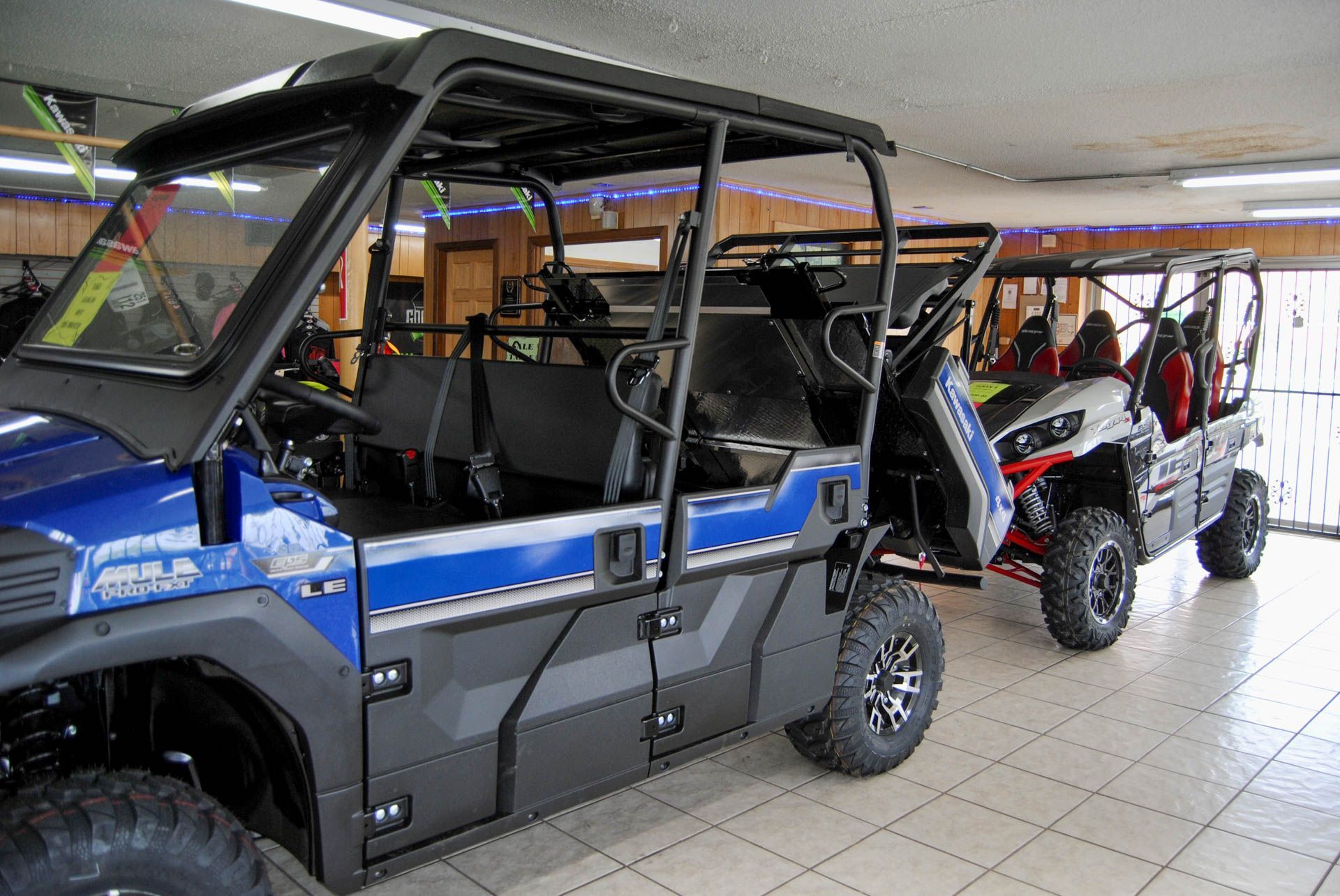 Two atvs are parked next to each other in a showroom.