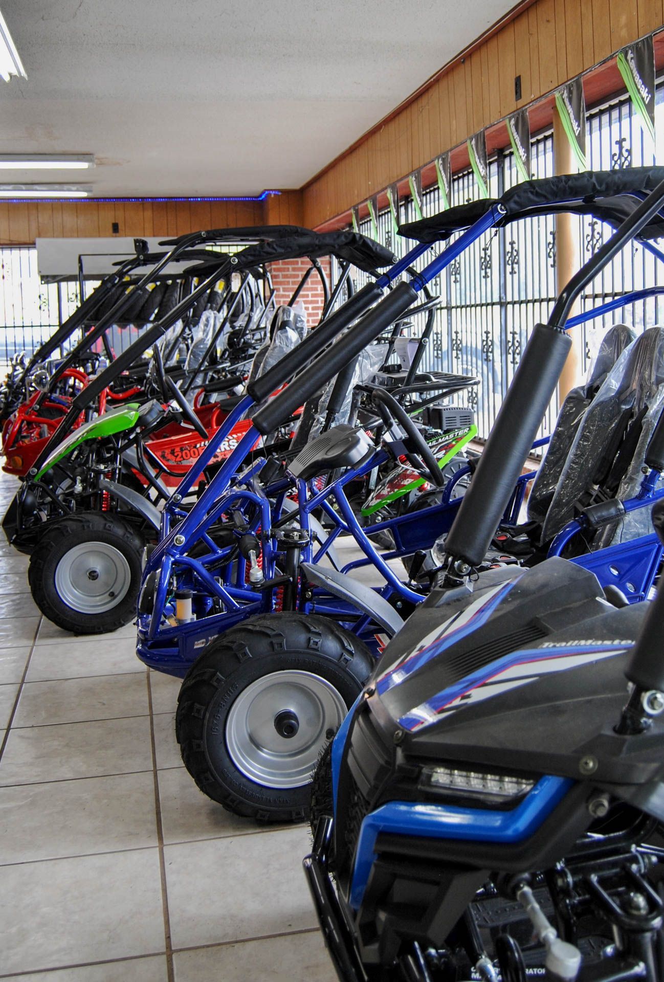A row of buggies are lined up in a showroom.