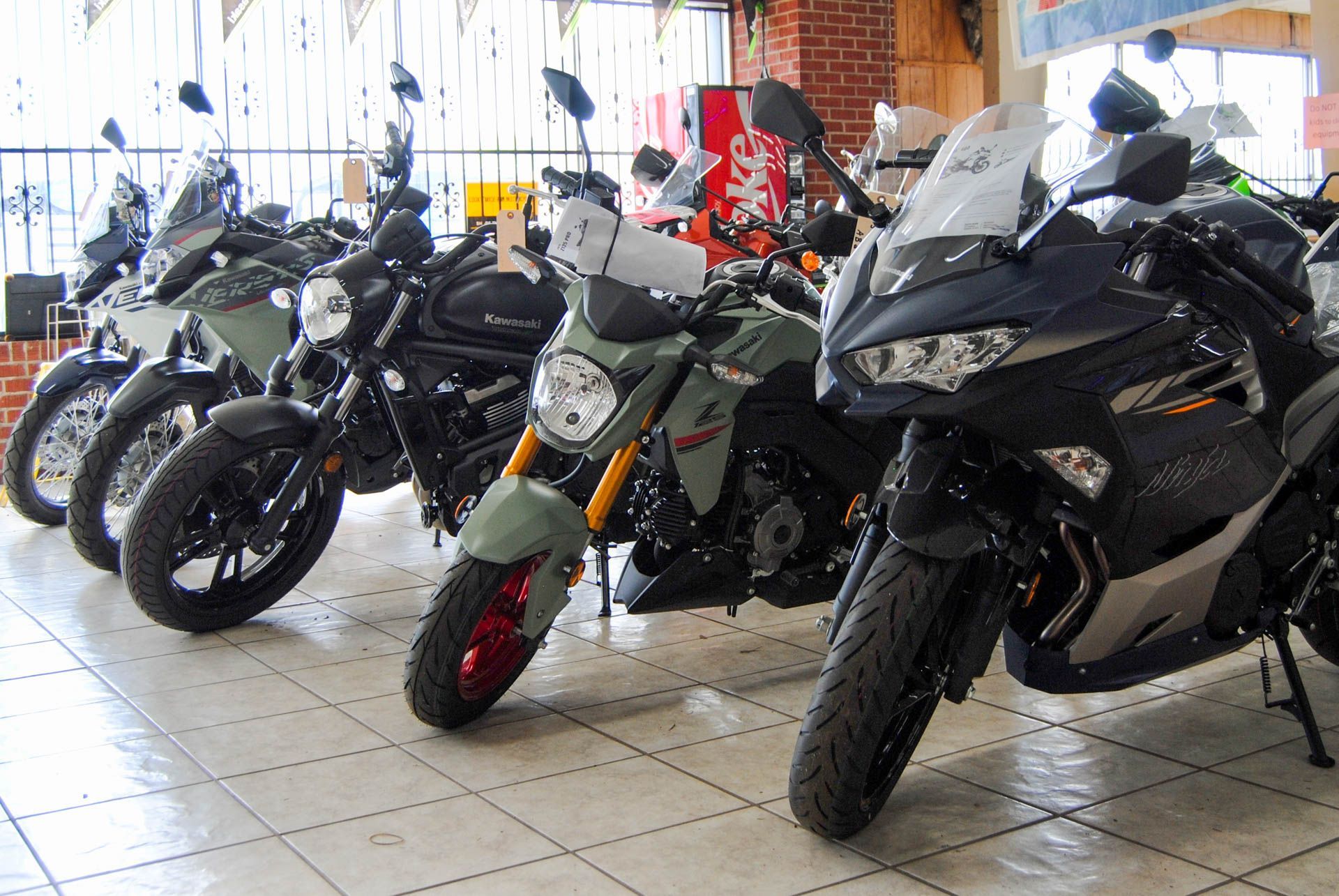A row of motorcycles are parked in a showroom.