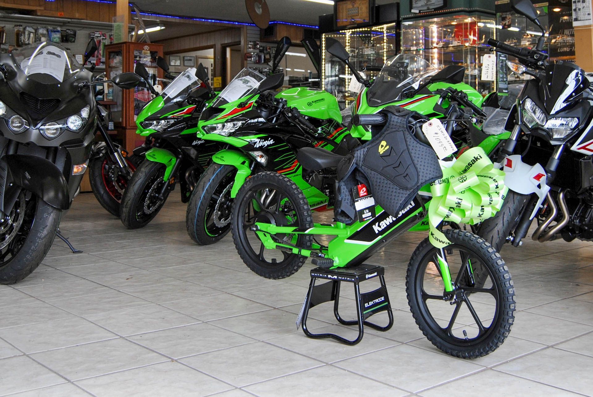 A row of kawasaki motorcycles are lined up in a showroom