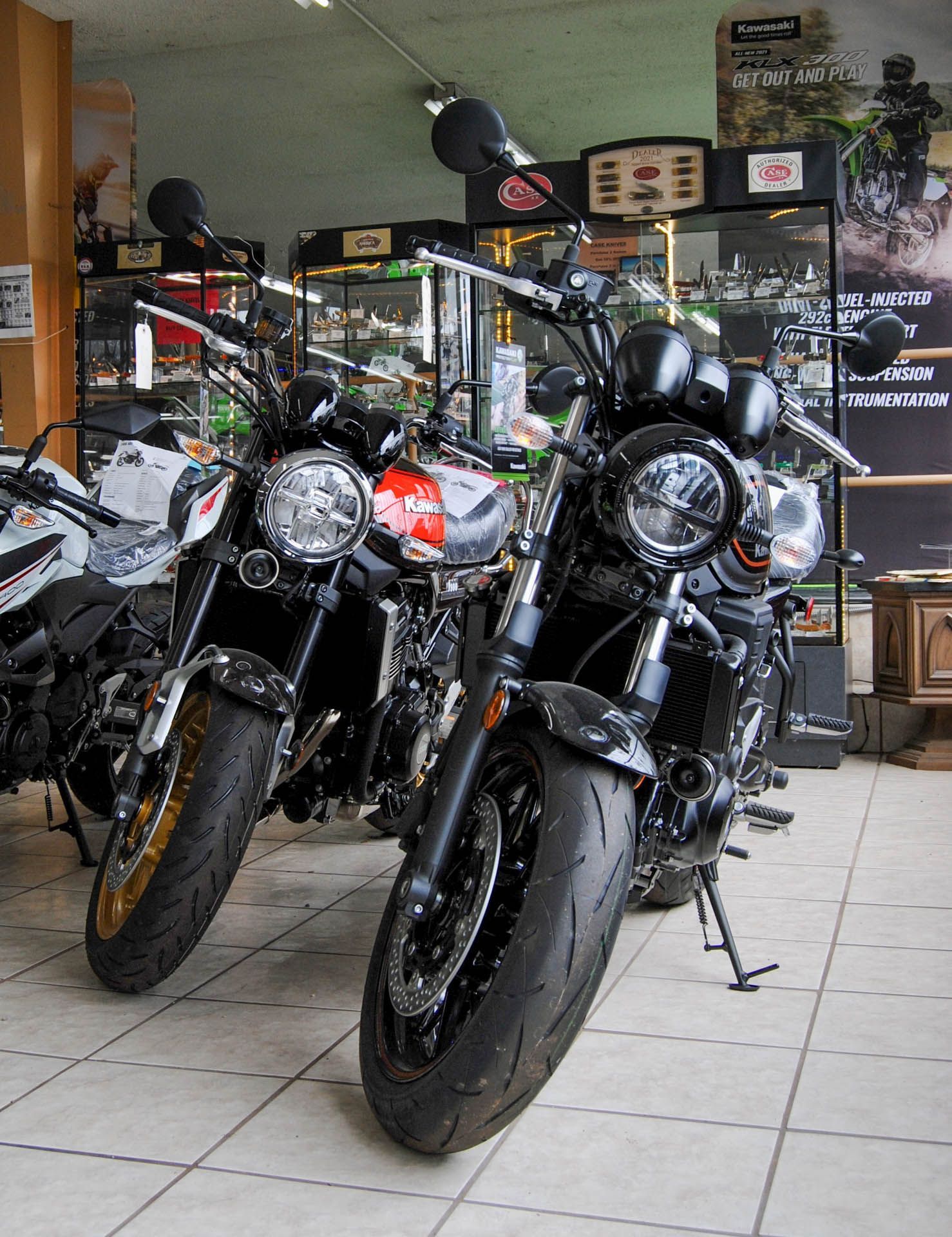 Two motorcycles are parked next to each other in a showroom.