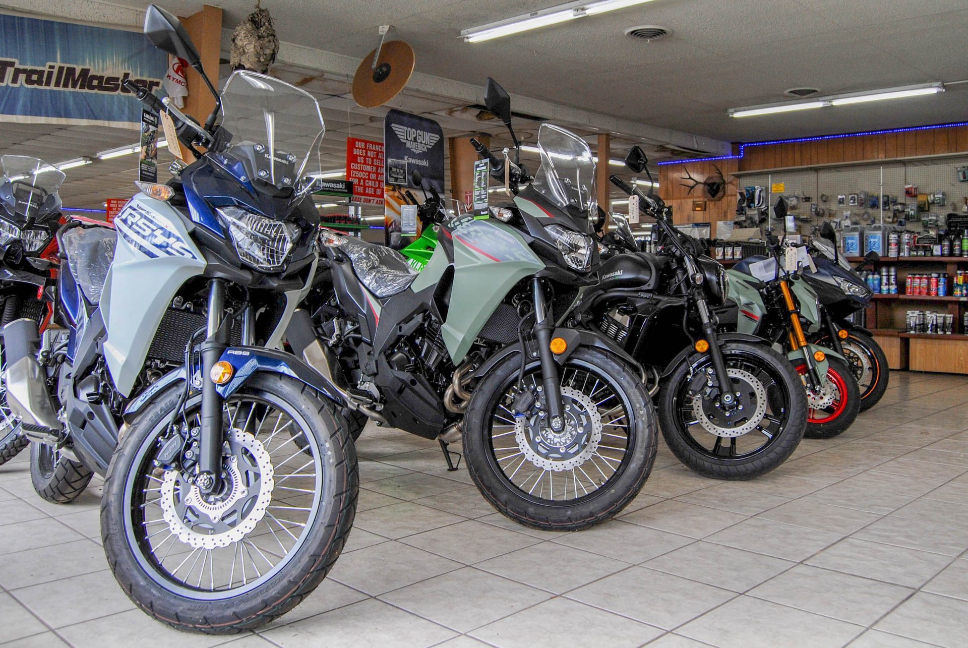 A row of motorcycles are parked in a showroom.