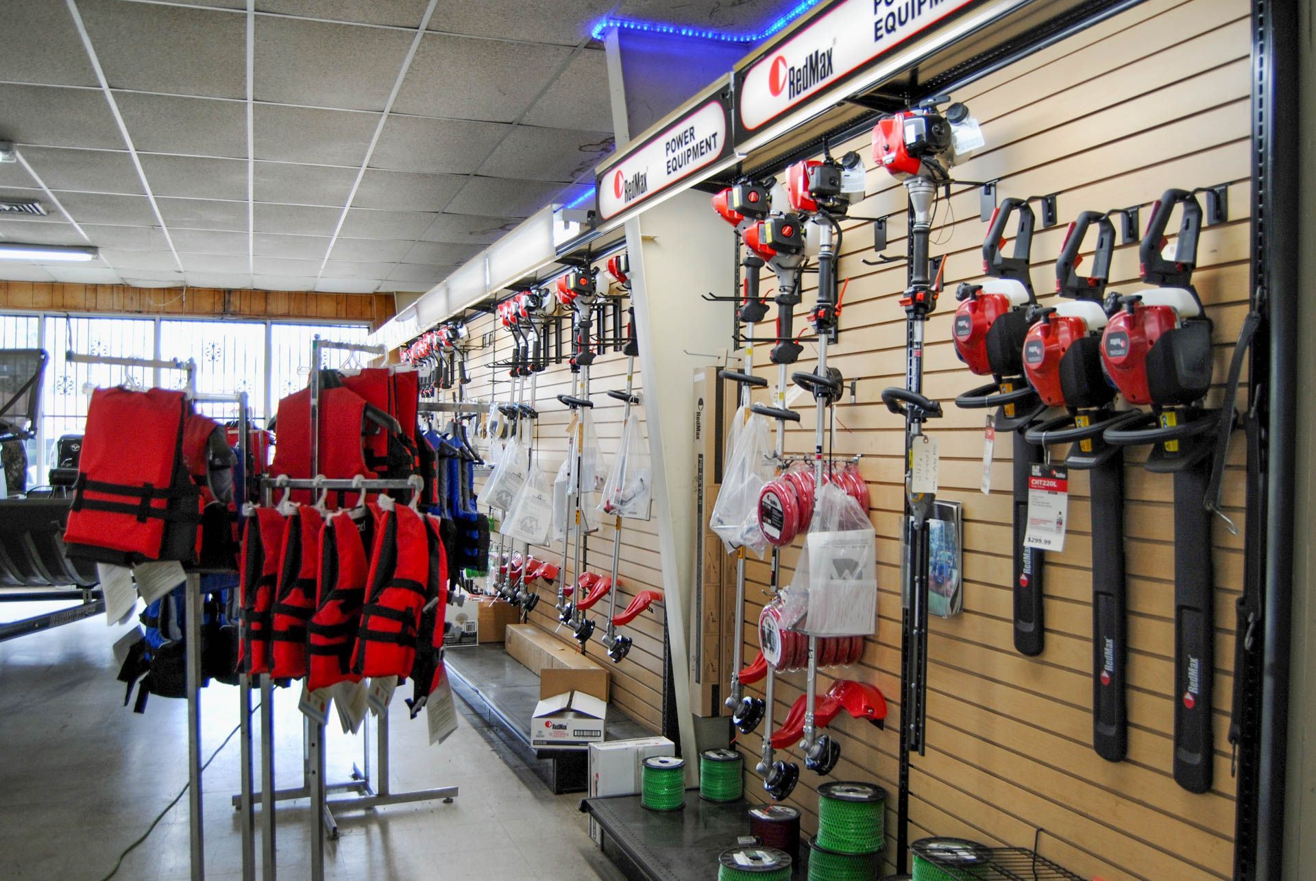 A store with a lot of red life jackets hanging on the wall