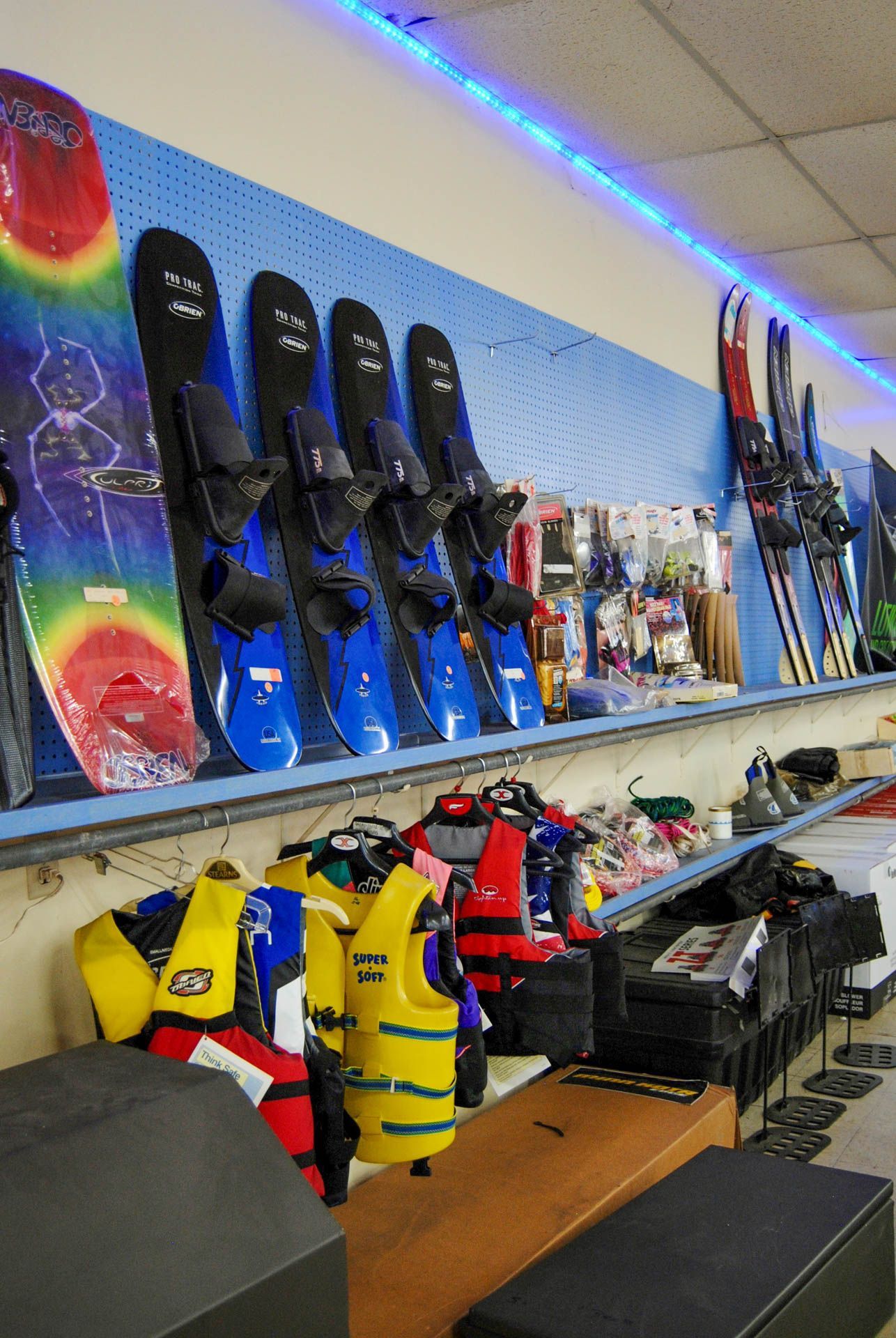 A bunch of skis and snowboards hanging on a wall in a store