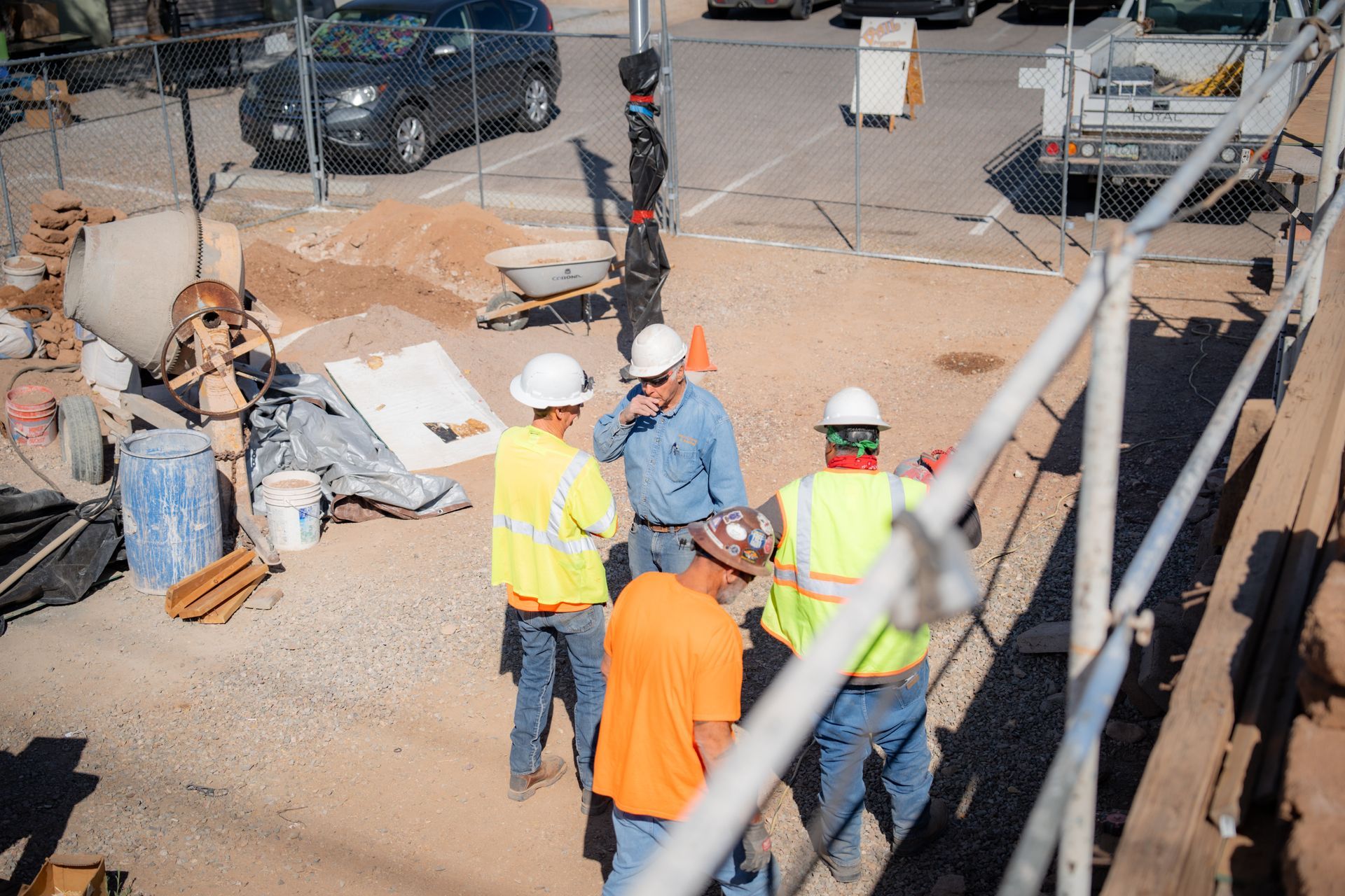 A group of construction workers are standing on a construction site.