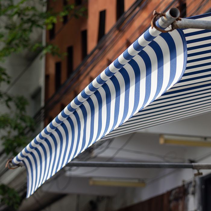 A blue and white striped awning on the side of a building