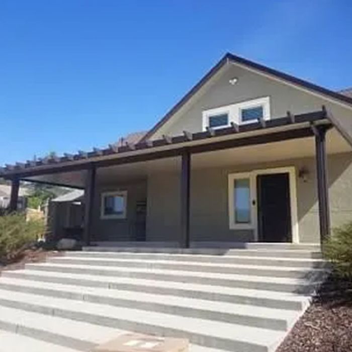 A house with stairs leading up to it and a porch.