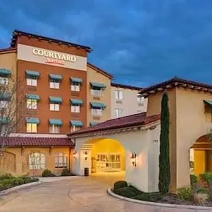 A large hotel with a lot of windows and a driveway leading to it.