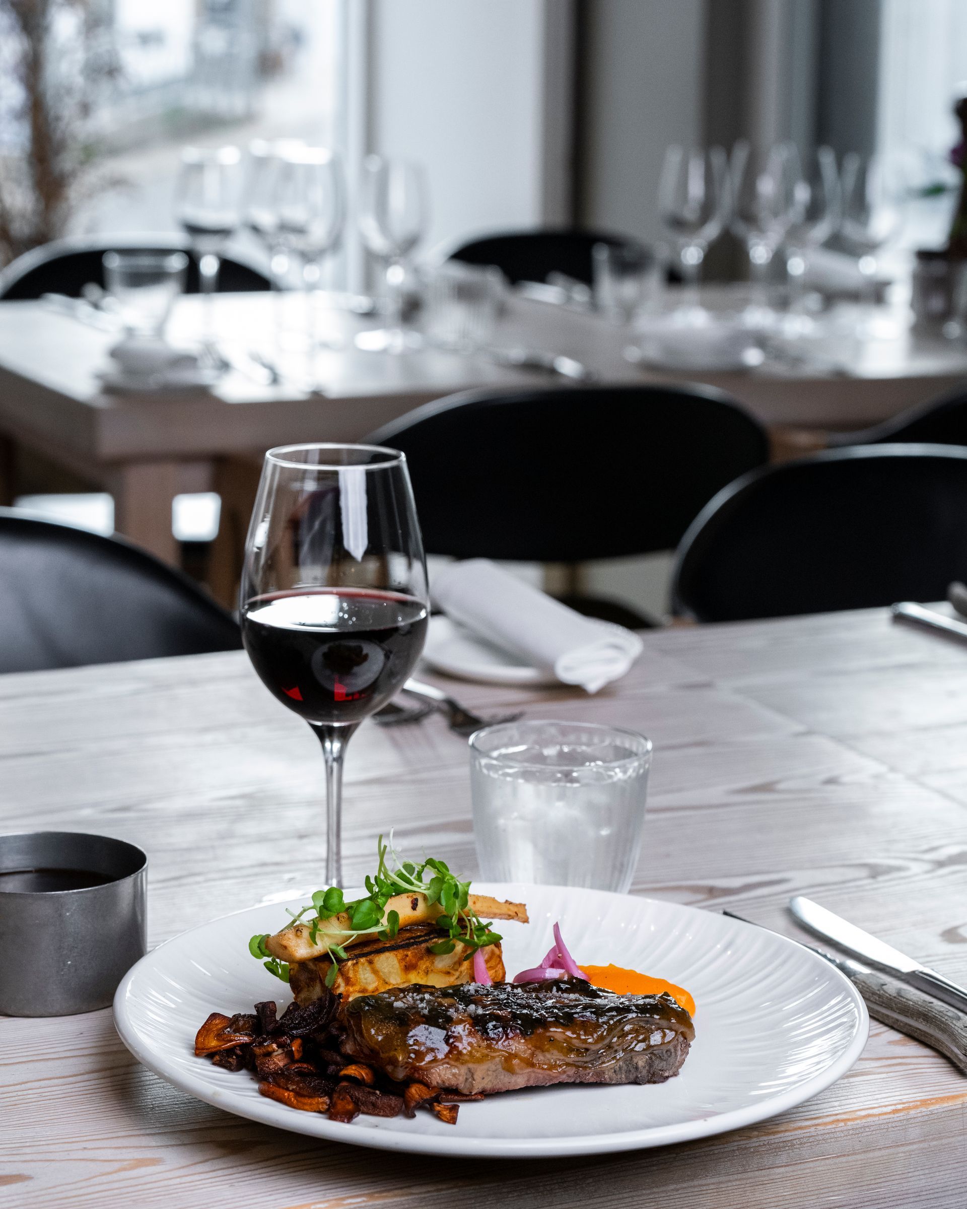 Bøfmiddag med rødvin på et bord i en restaurant.