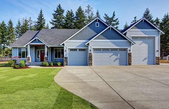 blue house with three different sized garage doors