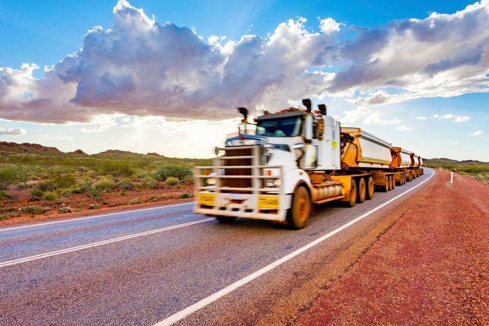 A Large Semi Truck is Driving Down a Dirt Road — Gillies Enterprises Pty Ltd In Coonabarabran, NSW