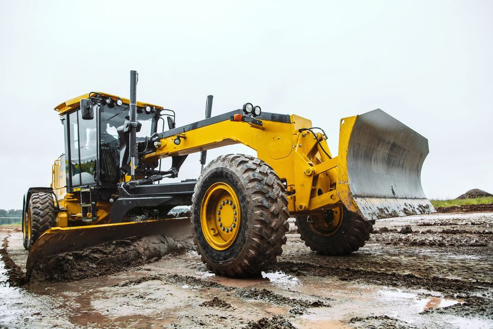 A Yellow Bulldozer Is Driving Through A Muddy Field — Gillies Enterprises Pty Ltd In Narrabri, NSW