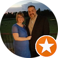 a man and a woman are standing next to each other in a circle with an orange star .
